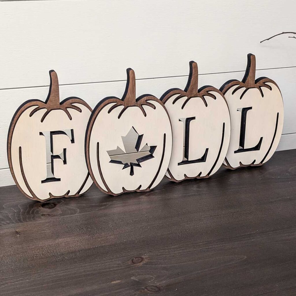 Pumpkin-shaped layered fall sign on a table