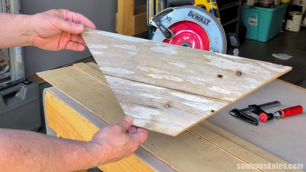 Person showing what the shelves look like after they've been cut