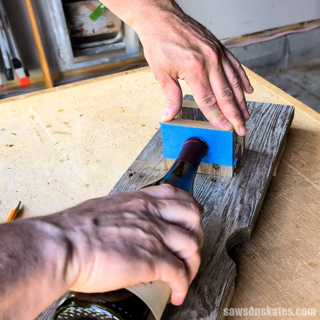 Positioning a wine bottle on a board with painter's tape