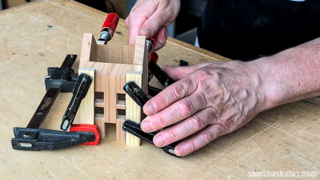Tighten clamps on a wood house luminary