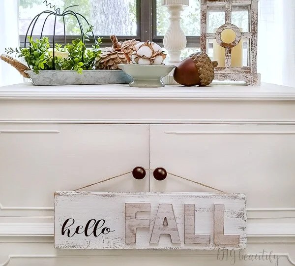 Wooden fall sign hanging on cabinet knobs