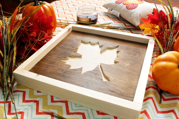 Framed maple leaf cut out of piece of plywood.