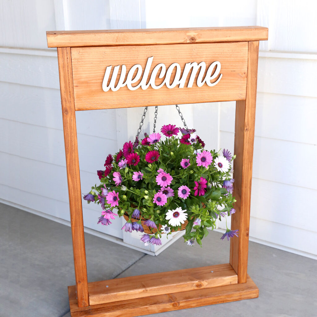 Wooden plant stand with a hanging basket on a porch