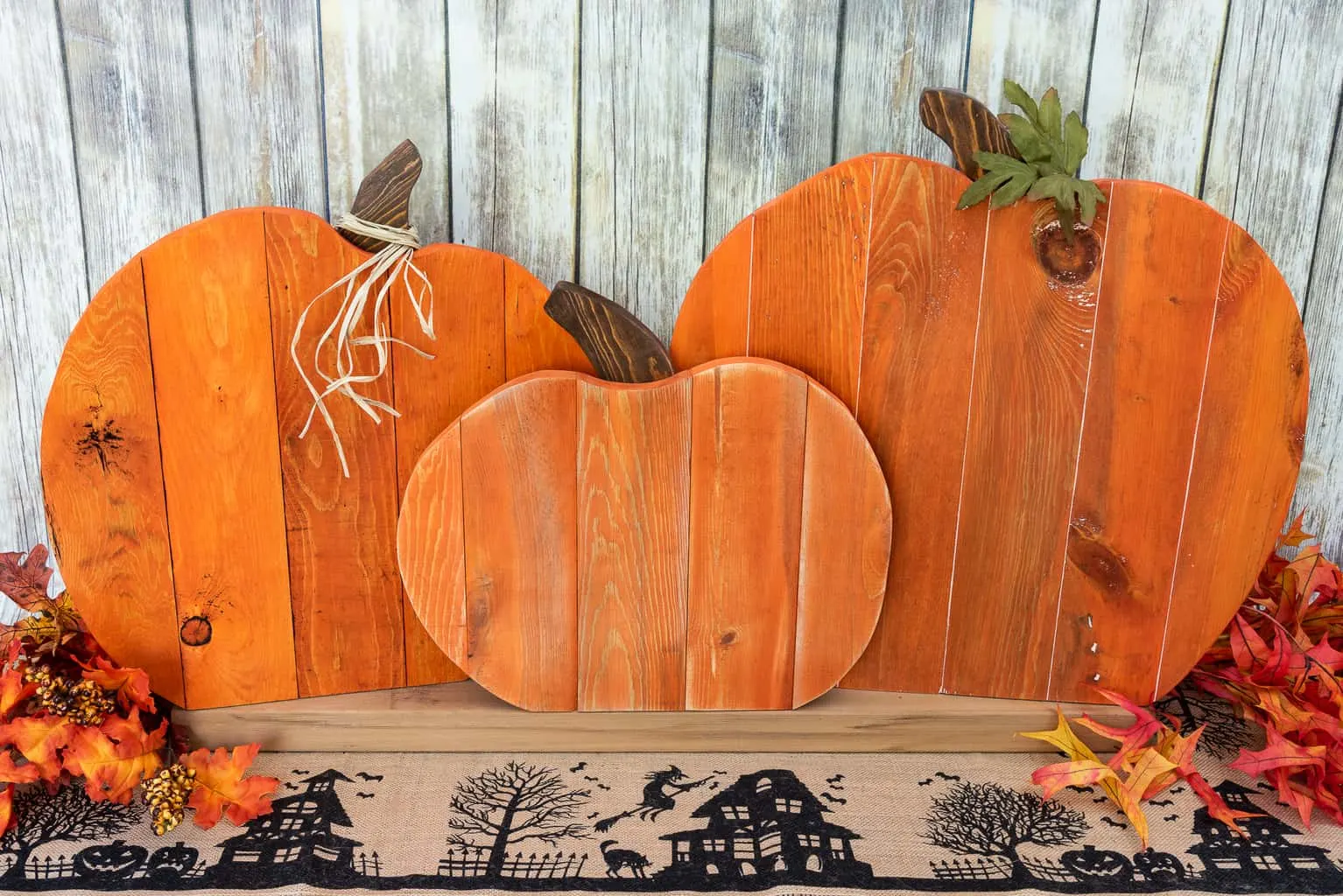 Three pumpkins, cut from pallets and painted orange