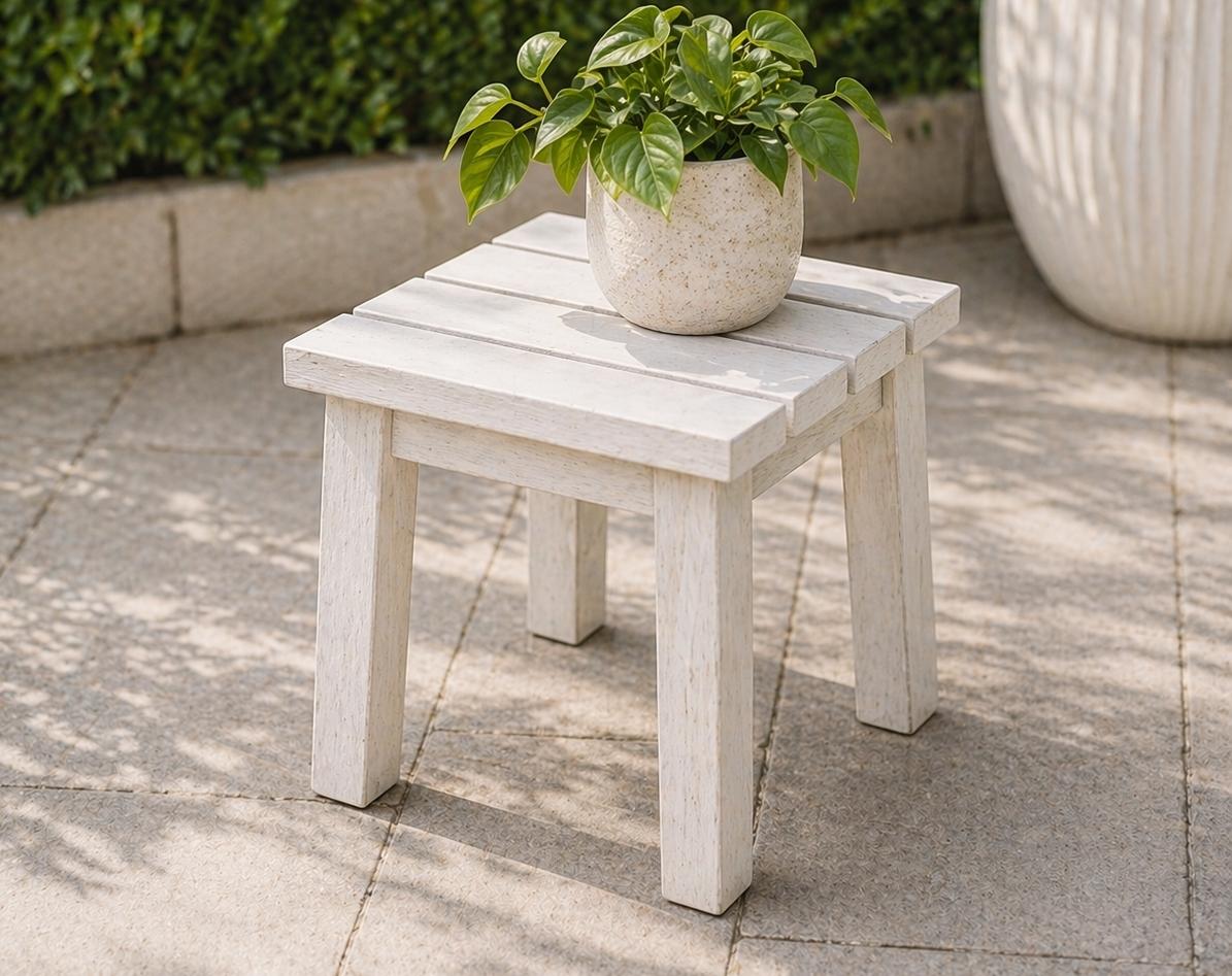 Wood plant stand painted white on a concrete patio