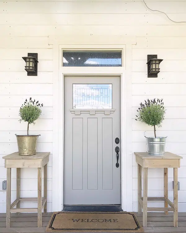 Pair of tall DIY outdoor side tables flank a front entry door.